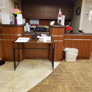 A view of a hotel lobby reception area featuring a wooden desk and organizational items.