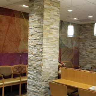 A modern waiting area featuring a stone pillar and contemporary seating arrangements.