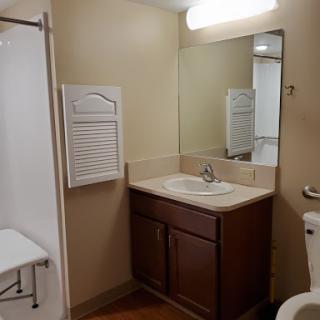 A simple and clean bathroom featuring a sink, toilet, and shower area.