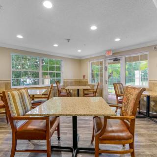 A bright and inviting dining area with several tables and chairs, featuring large windows that allow natural light to fill the space.