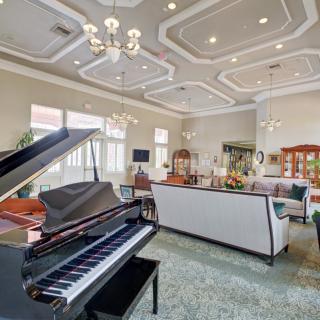A luxurious living room featuring a grand piano and elegant furnishings.