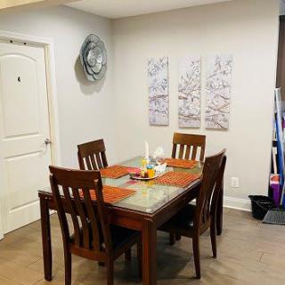 A cozy dining room setup with a wooden table and chairs, complemented by wall art and decor.