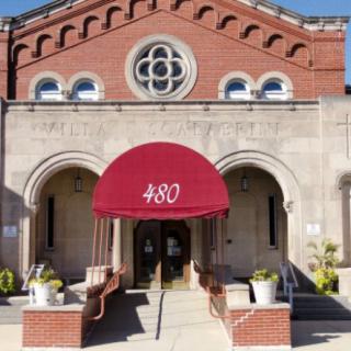 The front entrance of a brick building with a red awning labeled '480'.