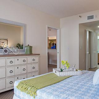 A cozy and modern bedroom interior with a neatly made bed and a stylish dresser.