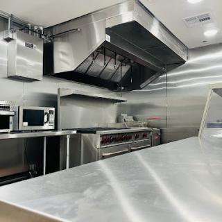 A modern and clean commercial kitchen equipped with stainless steel appliances.