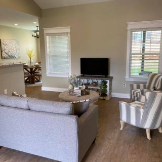 A cozy living room with a sofa, armchairs, and a television.