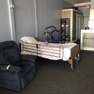 A hospital bed and a recliner chair in an interior space.