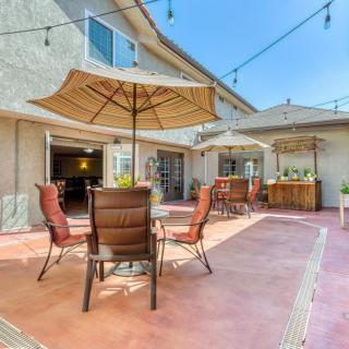 Spacious outdoor patio with seating and umbrellas under string lights.