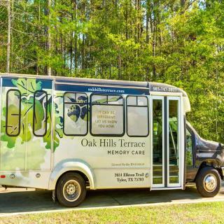 A decorated shuttle bus parked in a scenic outdoor environment.