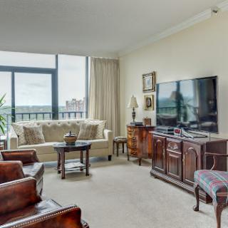 A cozy living room featuring modern furniture and a large window that provides natural light.
