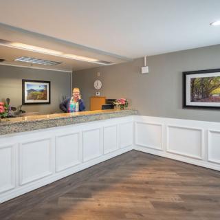 A reception area with a desk and artwork on the wall.