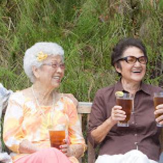 A joyful moment shared between friends enjoying drinks in a beautiful outdoor setting.
