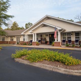 A residential building with a well-maintained garden and driveway.