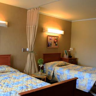 A cozy hotel room featuring two beds and warm lighting.