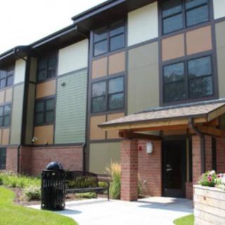 A modern apartment building exterior with a landscaped entrance.