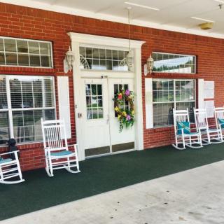 A welcoming porch with rocking chairs and a decorative wreath on the door.