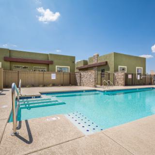 A serene outdoor swimming pool at a residential apartment complex, perfect for relaxation on a sunny day.