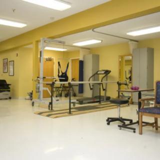 A rehabilitation room equipped with medical and exercise equipment for physical therapy.