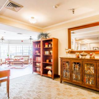 A warmly lit living room with a bookshelf and decorative cabinet.