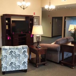 A cozy living room setup with a sofa, armchair, and entertainment center featuring a television.
