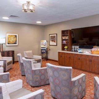 A comfortable waiting room with multiple chairs, a television, and a bookcase.