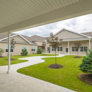 A serene courtyard surrounded by modern buildings, featuring manicured lawns and pathways.