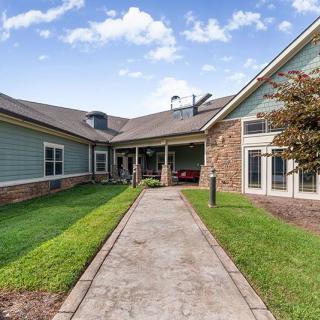 A modern residential house with a well-maintained lawn and pathway leading to the entrance.