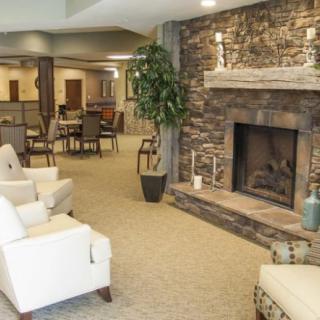 A cozy living room with a stone fireplace and comfortable seating area.