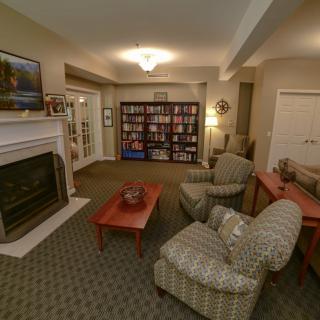 Cozy living room with a fireplace, armchairs, and a bookshelf.