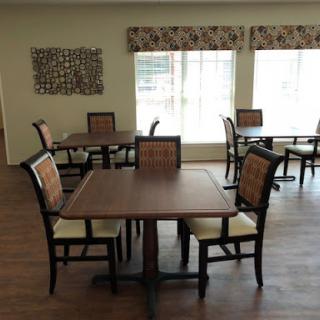 A spacious and well-lit dining area featuring wooden tables and chairs.