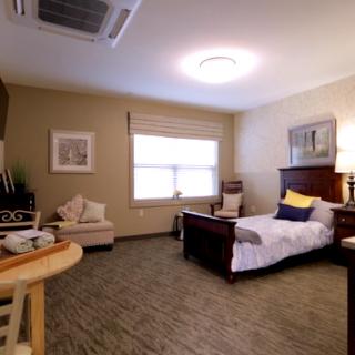 A cozy bedroom with a single bed, comfortable chair, and tasteful decorations.