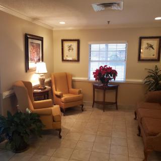 A cozy waiting area featuring comfortable seating, artwork, and decorative plants.