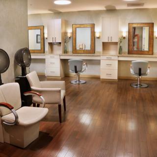 An elegant hair salon interior with styling chairs and large mirrors.