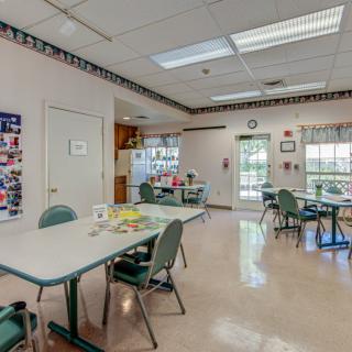 A bright classroom with tables and chairs arranged for group activities.