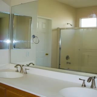 A clean bathroom with a double sink vanity and a shower.
