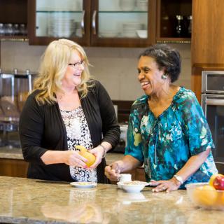 Two women enjoying a conversation in the kitchen.