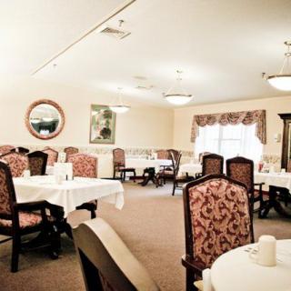 An elegantly decorated dining room with multiple tables and chairs set for a meal.