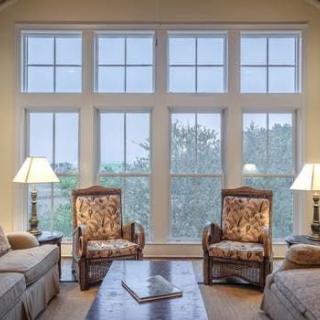 A cozy living room with large windows and comfortable seating.