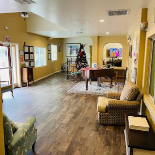A spacious and inviting lobby featuring comfortable seating, warm colors, and a decorative tree.