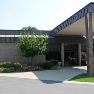 A modern building entrance with landscaping and a tree.