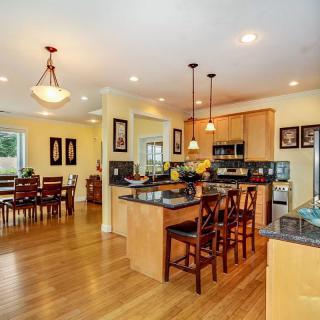 A spacious open-plan kitchen and dining area with modern amenities and hardwood flooring.