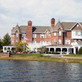 A large, elegant mansion located by the water's edge.