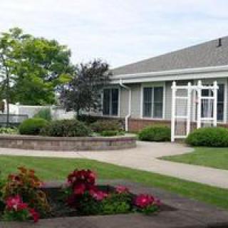 A well-maintained garden with flowers and a pathway leading to a building.