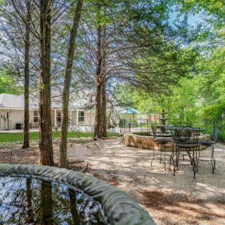 A peaceful outdoor patio area surrounded by trees and greenery.