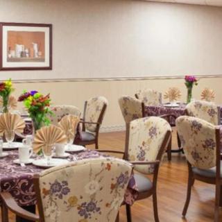 A cozy dining room setup with floral tablecloths and flower centerpieces.