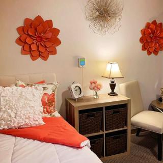 A cozy bedroom featuring orange wall decorations and warm lighting.