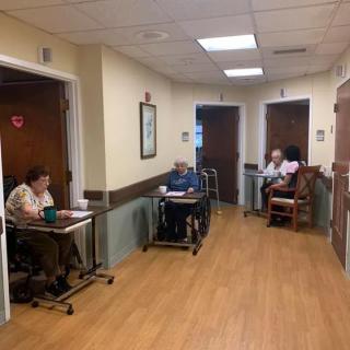 Elderly residents sitting in the hallway of a nursing home.