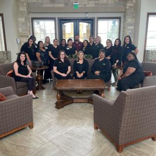 A group of people posing together in an office setting.