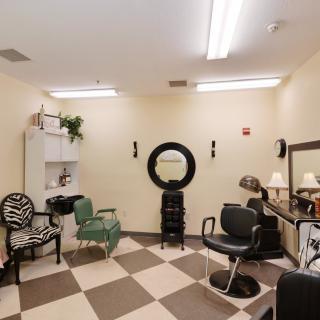 A cozy hair salon with various styling chairs and mirrors, featuring a checkered floor design.