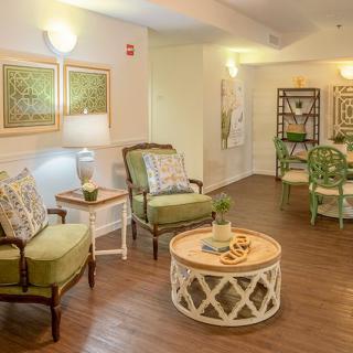 A cozy living room with comfortable chairs, a decorative coffee table, and warm lighting.